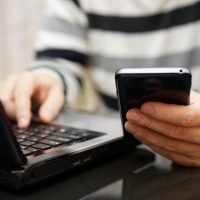 Teenager Addicted To The Internet And Social Media Using Phone A Teenager addicted to the Internet and Social Media using phone and laptop at the same time