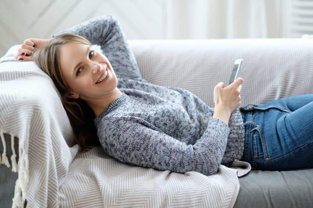 woman happy on ouch after toronto upholstery cleaning